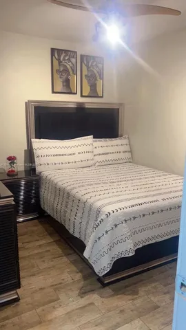 a bedroom with a bed and painting on the wall