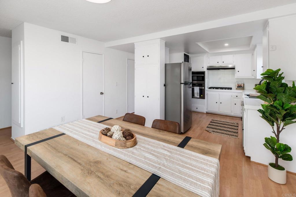 201 4th Street, Unit A/B Encinitas, CA 92024 - Photo 13 of 33 a view of kitchen island with stainless steel appliances furniture refrigerator and wooden floor