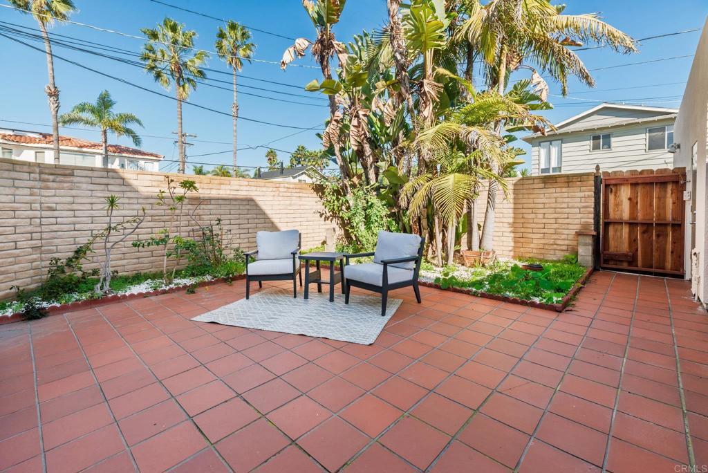 201 4th Street, Unit A/B Encinitas, CA 92024 - Photo 24 of 33 a view of a patio with table and chairs potted plants and wooden fence