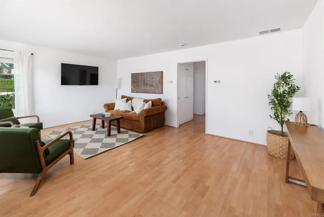 a view of a hallway with wooden floor and closet