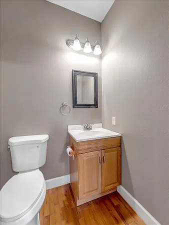 a bathroom with a toilet a sink and mirror