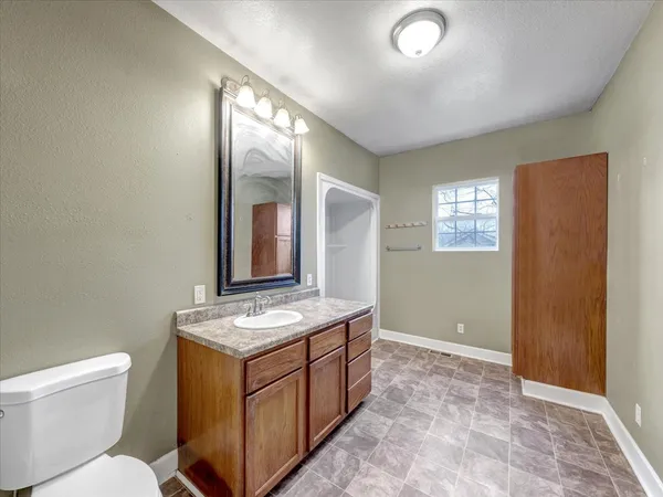 a bathroom with a toilet sink and mirror