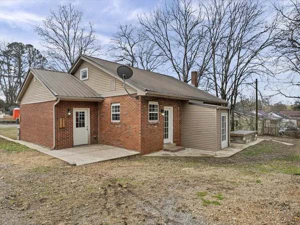a view of a house with a yard and large tree
