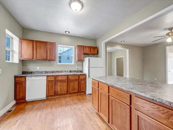 a kitchen with stainless steel appliances granite countertop wooden cabinets a granite counter tops and a window