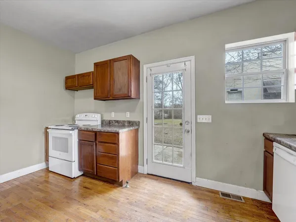 a kitchen with stainless steel appliances granite countertop a stove a sink and a refrigerator with wooden floor