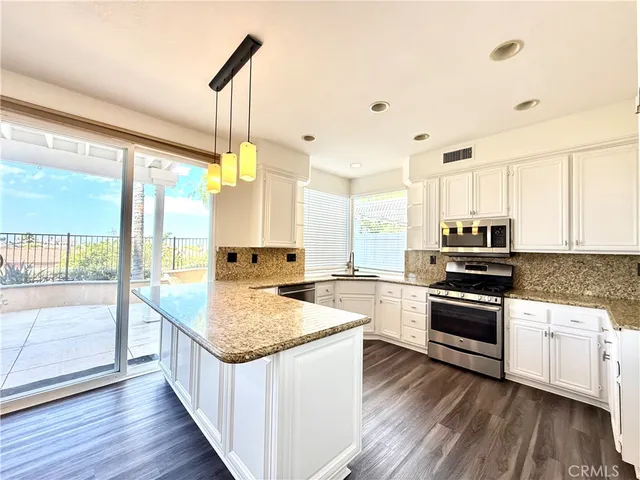 a kitchen with sink stove and refrigerator