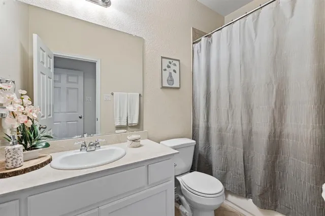 a bed sitting in a bedroom next to a window and chair