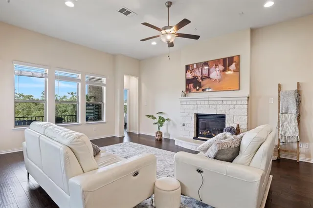 a living room with furniture a fireplace and a large window