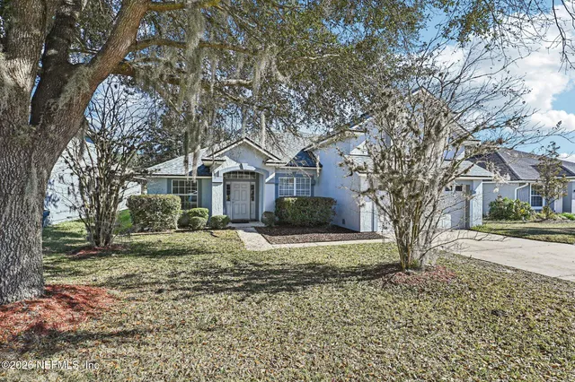 a view of a house with a yard covered in snow