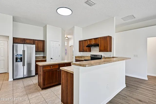 a kitchen with a sink cabinets and wooden floor