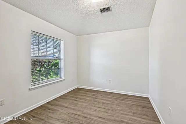 a view of a room with wooden floor and a window