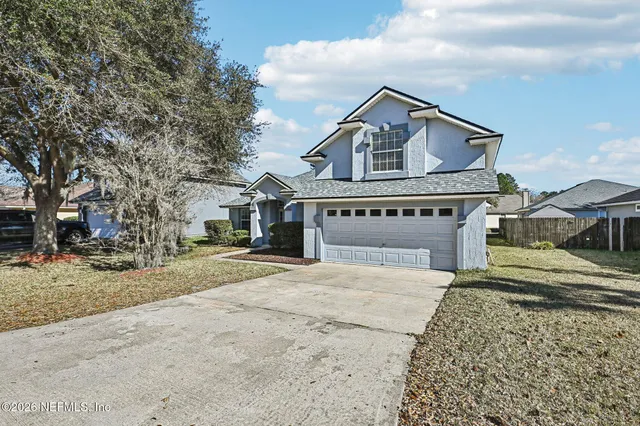 an empty room with wooden floor mirror and windows