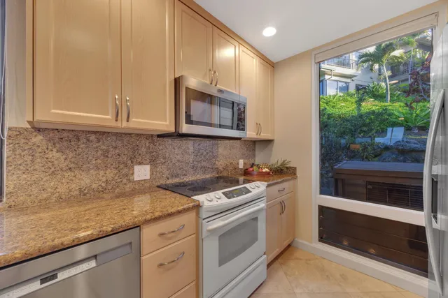 a kitchen with stainless steel appliances white cabinets and a stove top oven