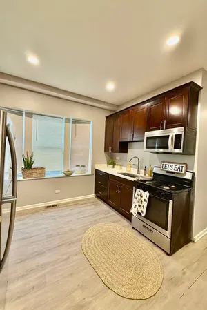 a kitchen with stainless steel appliances kitchen island granite countertop a stove a sink and a microwave