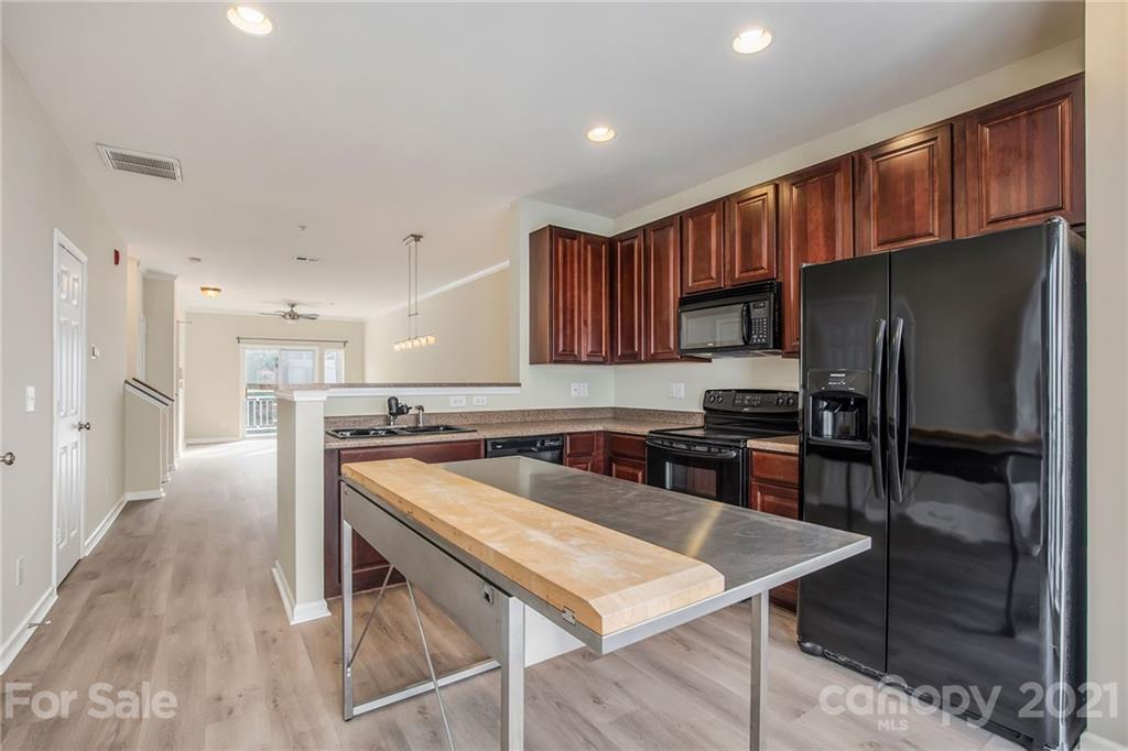 642 Raphael Place Charlotte, NC 28205 - Photo 12 of 27 a kitchen with stainless steel appliances granite countertop a refrigerator a stove a sink a dining table and chairs