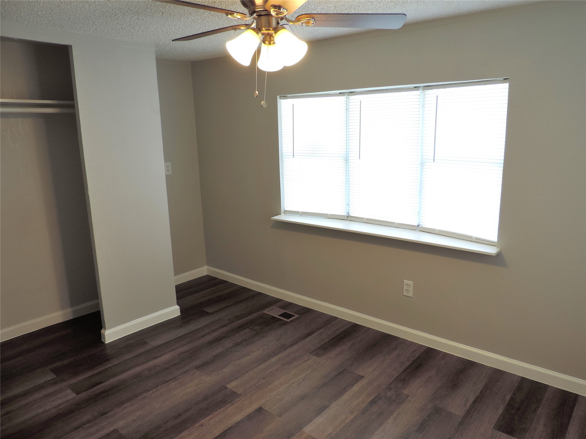 1668 Fm 2518, Unit 85 Cleveland, TX 77327 - Photo 4 of 8 an empty room with wooden floor fan and windows