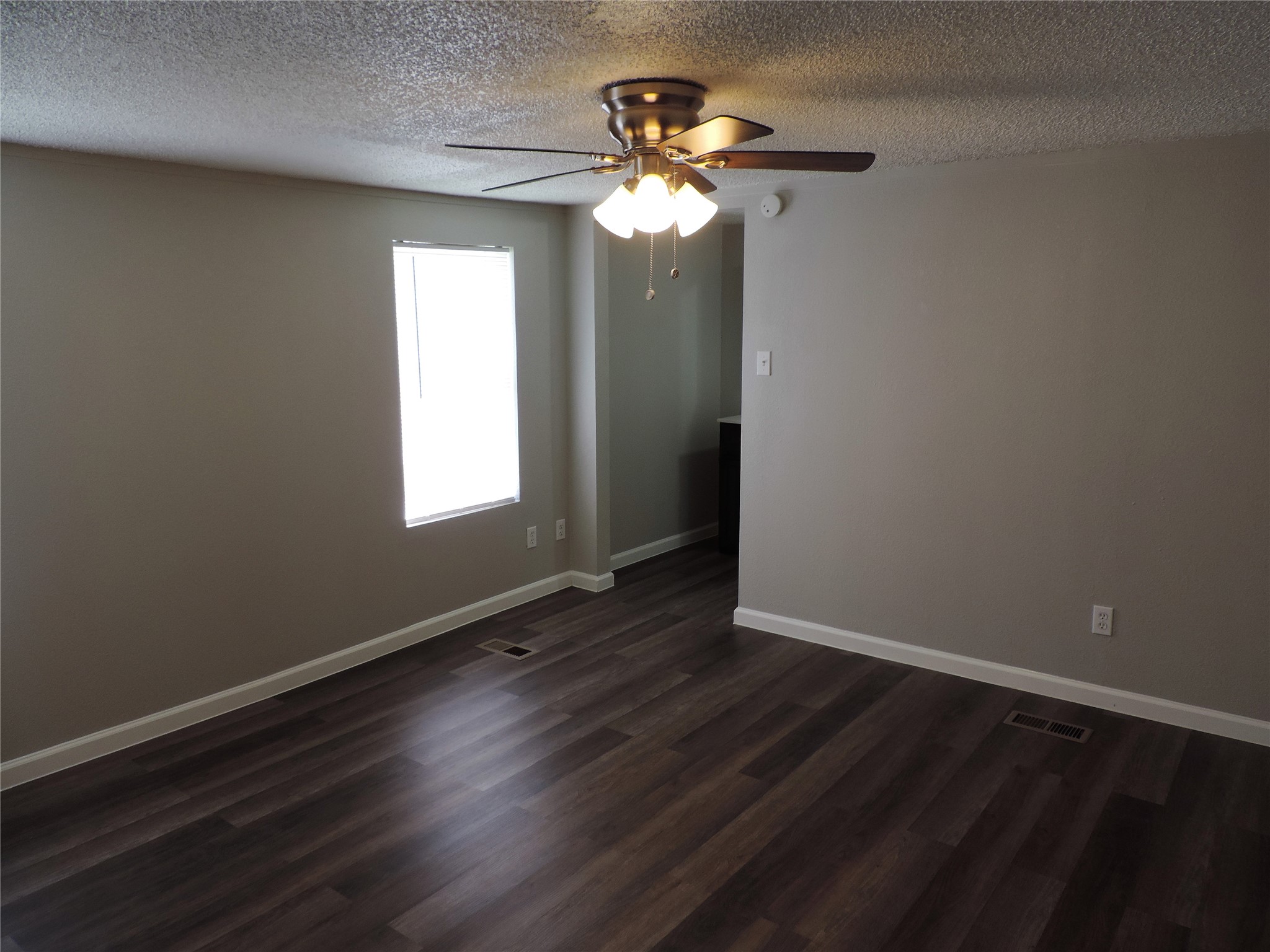 1668 Fm 2518, Unit 85 Cleveland, TX 77327 - Photo 6 of 8 a view of an empty room with wooden floor and a window