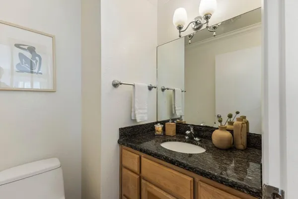 a bathroom with a granite countertop sink and a mirror