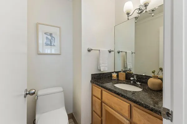 a bathroom with a granite countertop sink a toilet and a mirror