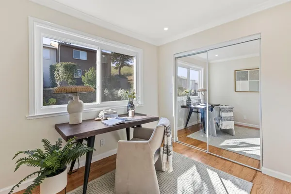 a dining room with furniture a floor to ceiling window and potted plants