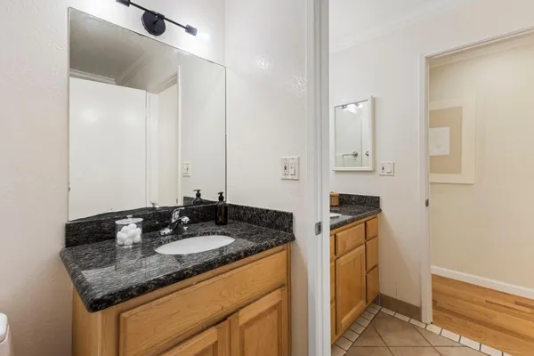 a bathroom with a granite countertop sink and a mirror