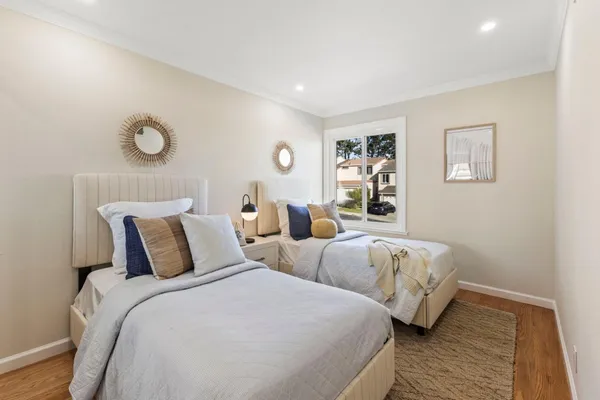 a bedroom with two beds and a lamp