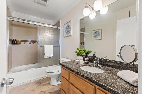 a bathroom with a granite countertop sink a toilet and a mirror