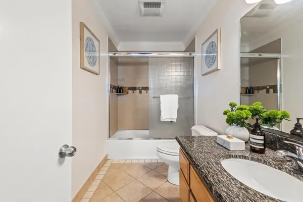 a bathroom with a granite countertop sink a mirror and a shower