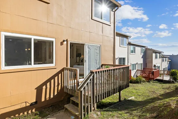 a view of a house with a small yard and wooden fence