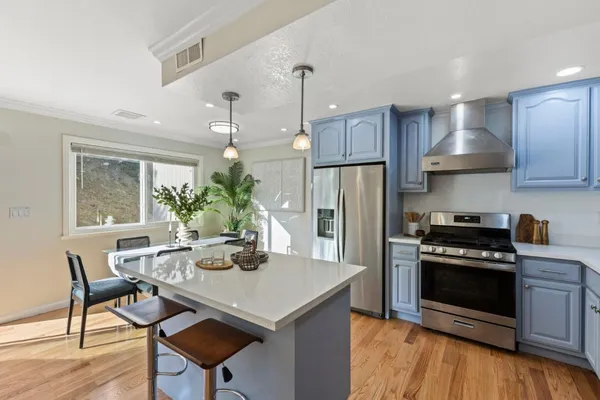 a kitchen with kitchen island a stove a table and chairs in it