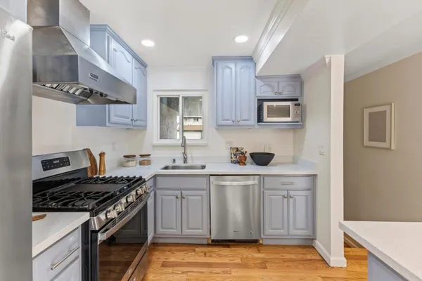 a kitchen with stainless steel appliances a sink stove and cabinets