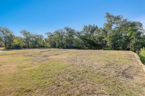 a view of a field with trees in the background