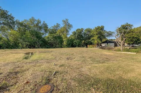 a view of a field with trees in the background