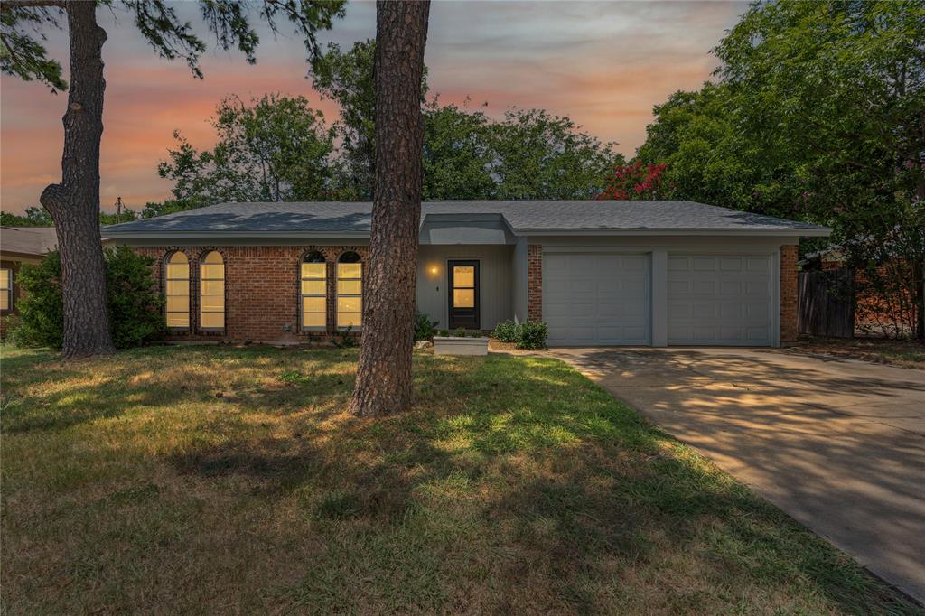 a front view of house with yard and trees around
