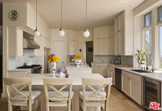 a kitchen with a dining table chairs sink and stove top oven