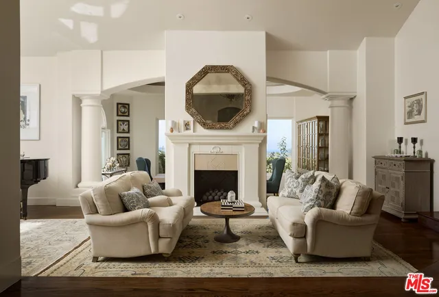 a living room with furniture a fireplace and a floor to ceiling window
