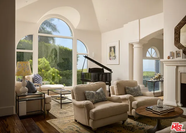 a living room with furniture a large window and a fireplace