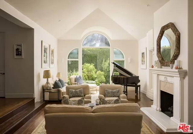 a living room with furniture a fireplace and a large window