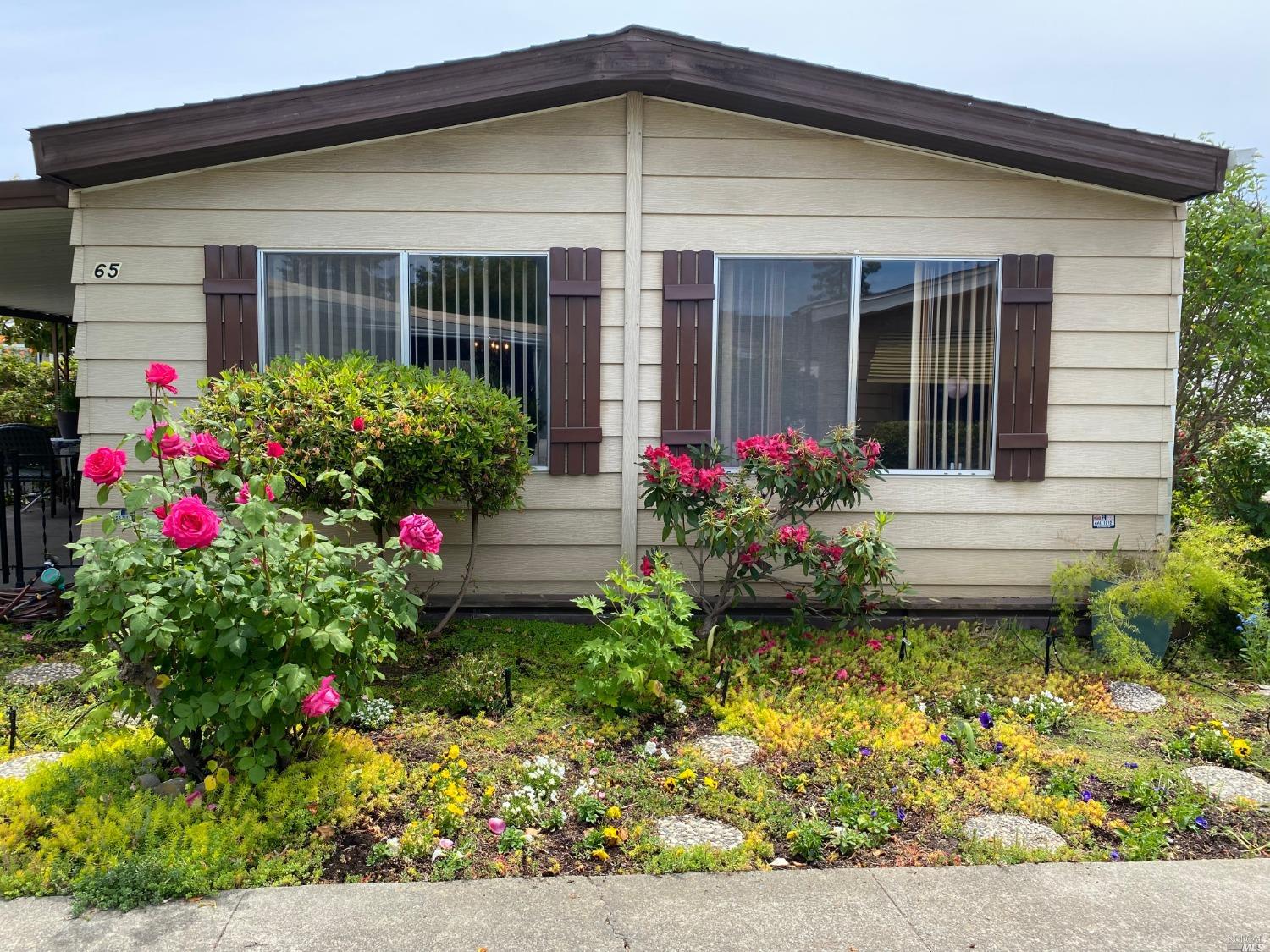 a flower garden is sitting in front of a house