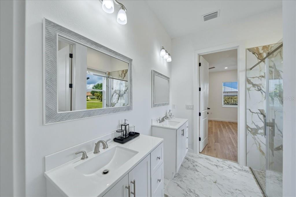 1215 Rio De Janeiro Avenue Punta Gorda, FL 33983 - Photo 46 of 65 a bathroom with a double vanity sink mirror and shower