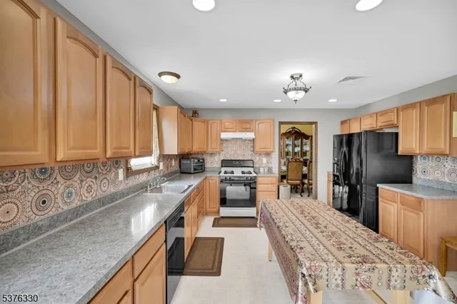 a large kitchen with kitchen island granite countertop a large counter top appliances and cabinets