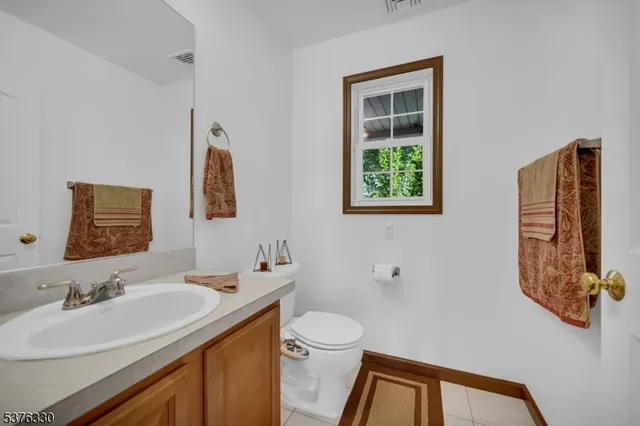 a bathroom with a sink vanity granite and toilet