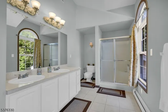 a spacious bathroom with a double vanity sink a mirror and a shower