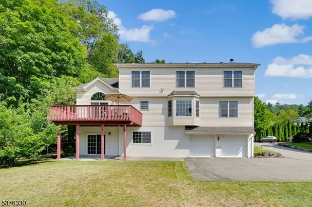 a view of a white house with large windows and a table and chairs