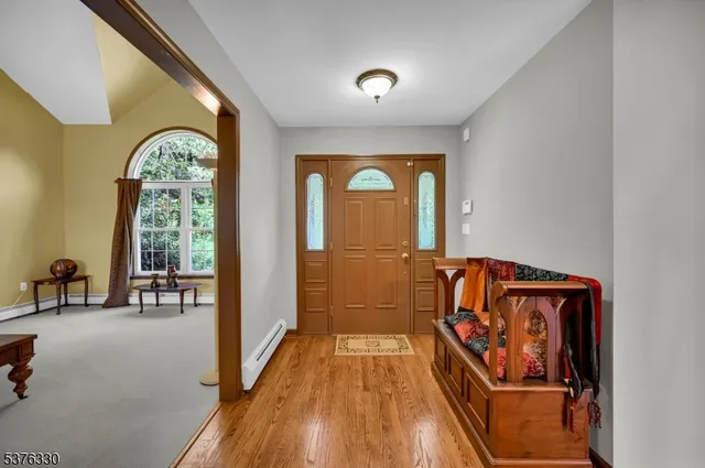 a view of a hallway with wooden floor and windows with curtains