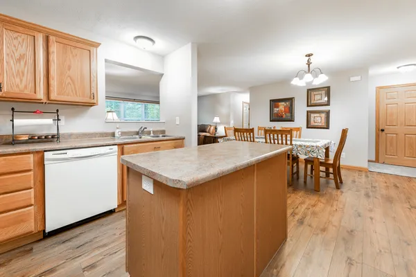 a kitchen with stainless steel appliances granite countertop a table chairs and a refrigerator