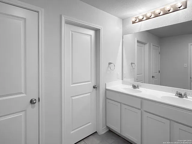 a bathroom with a double vanity sink and mirror