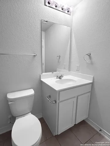 a bathroom with a toilet sink and mirror