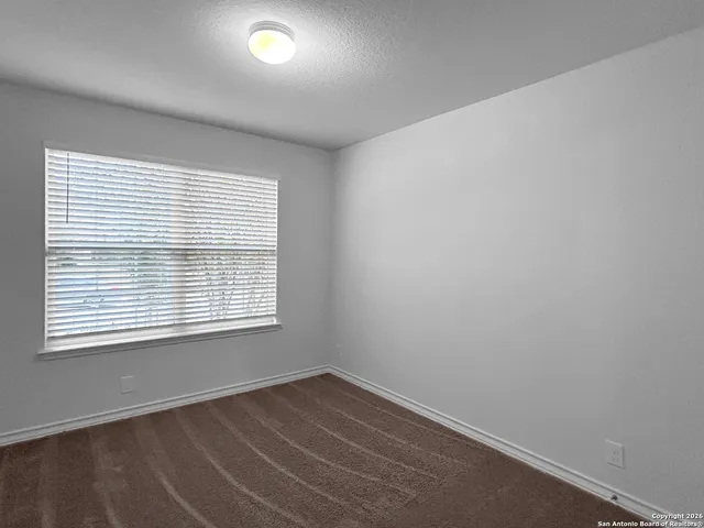 an empty room with wooden floor and a window