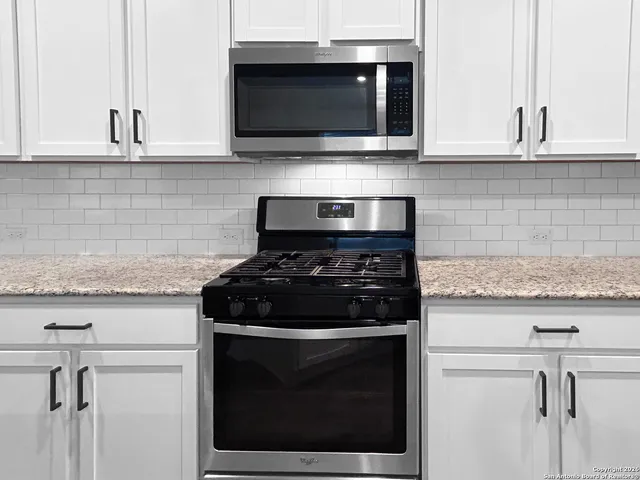 a kitchen with microwave stove and cabinets